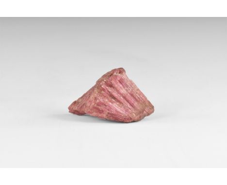 An unusual piece of rubellite tourmaline composed of numerous minute radiating crystals of a deep pink colour, in white card 