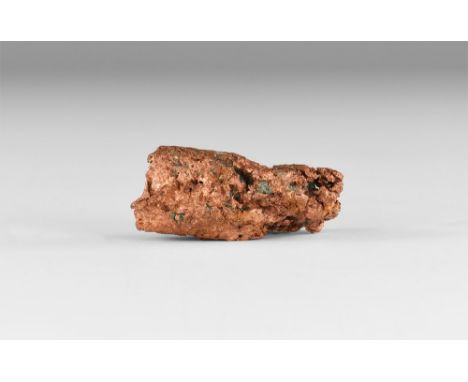A piece of 'float copper', or butchite, of a coppery pink colour and with small areas of inclusions,in white card tray with l