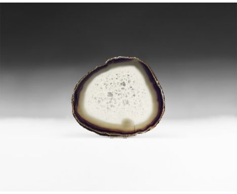 A massive cut and polished agate slice showing bands of blue and brown colour to the border, honeycomb quartz crystals to the