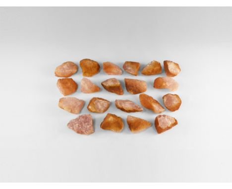 A group of twenty straight-from-the-Earth rose quartz chunks with waxy lustre and removable iron staining. See Bonewitz, Dr. 