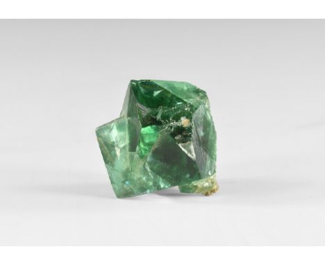 A group of fluorite crystals consisting of interlocking square crystals with rainbow reflections, in white card tray with Gre
