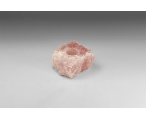 A large, roughly square piece of rose quartz with deep pink colour and bands of white throughout; cut to the top with a cylin
