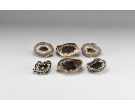 A group of three cut and polished geode pairs, one with amethyst crystals, one with quartz crystals framed by minute amethyst