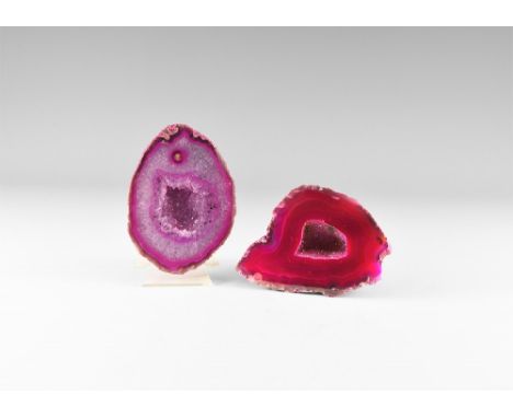 Two cut and polished agate geode halves with pinkish red bands and with central cavities with clusters of small crystals, col