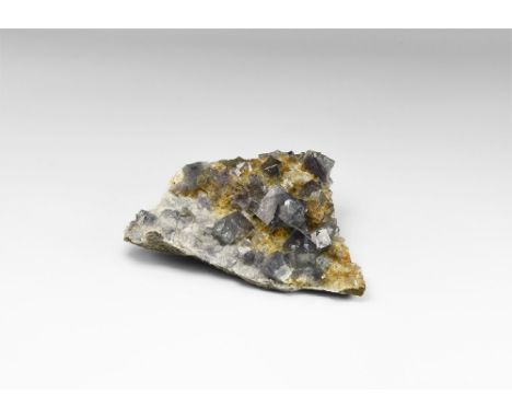 A specimen consisting of numerous lustrous and transparent purple cubic crystals of fluorite on matrix with a number of penet