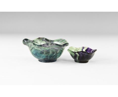 A pair of carved fluorite bowls with carinated rims, tapering bodies and small base ring; bodies with bands of colour ranging