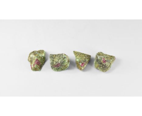 A group of four plum coloured rubies in a zoisite matrix from Zaire, in white card trays. See Bonewitz, Dr. Ronald Louis, Roc