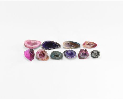 A group of ten cut and polished agate geodes of varying colours and with clusters of crystals in the central cavities; colour