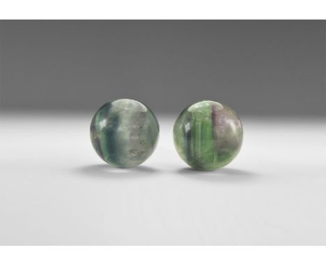 A pair of flourite spheres with a pale green colour and with flecks of red and rainbow reflections. See Bonewitz, Dr. Ronald 