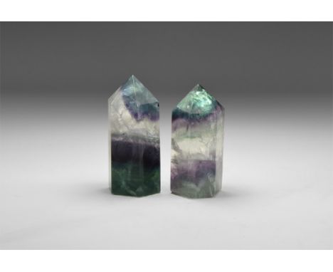 A pair of large prism cut fluorite polished points with bands of colour ranging from jade green, purple and clear, with 'rain