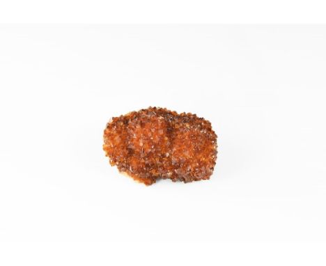 A citrine 'porcupine' of dense small crystals, some with dark brown tips, in white card tray with label reading: 'CITRINE POR