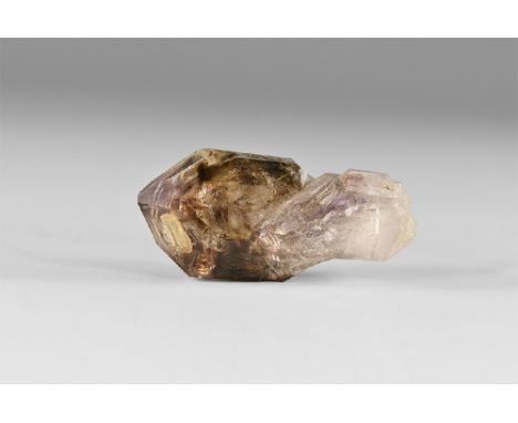 A large double termination crystal showing smoky quartz to one end and amethyst at the other; with attached amethyst sub crys