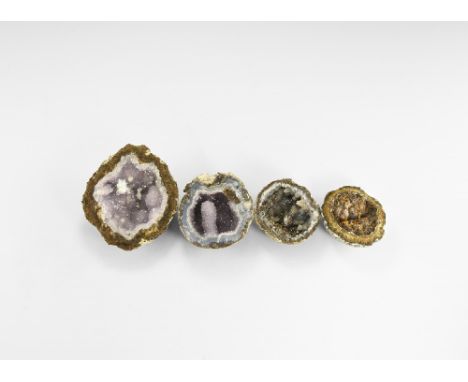 A group of four split amethyst geode halves each with an unusual colour and crystal growth, two with secondary crystal growth