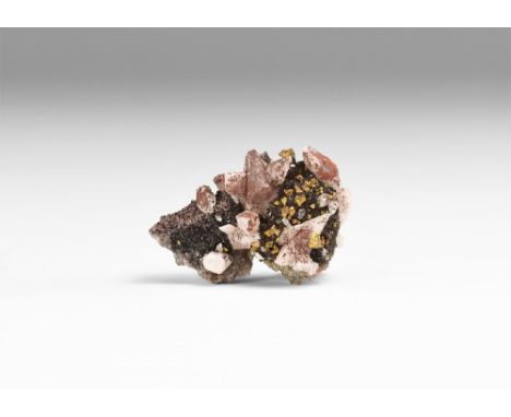 A specimen consisting of scalenohedral calcite crystals upon which rest tetrahedrite crystals, in white card tray with label 