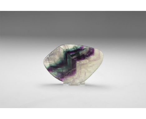 A large polished, flat flourite with rounded edges, bands of colour ranging from jade green, purple and clear, with 'rainbow'