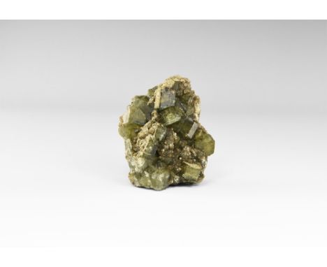 A group of semi-transparent, blocky, yellow-green apatite encrusting quartz, with small globular crystals of an unidentified 