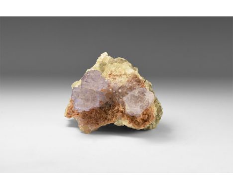 A specimen consisting of two large formations of intergrown fluorite cubes resting on a matrix of white and smokey grey cryst