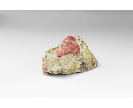 A specimen consisting of four vivid pink grossular garnet crystals in matrix, from Mexico, in old white card tray. See Bonewi
