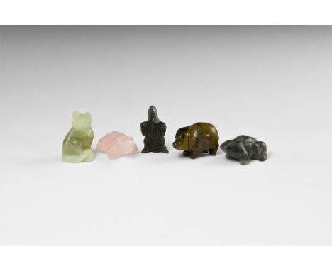 A group of carved gemstone animals including: an obsidian frog, labradorite eagle, fluorite cat, tigers eye pig, rose quartz 