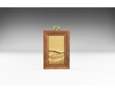 A framed sheet of paesina with the layers picked out in iron oxide minerals displaying the characteristic naturally occuring 
