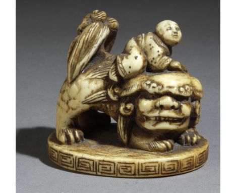 A mid 18th century Japanese netsuke from Edo period. Not signed. In carved elephant ivory portraying a Sennin sat on a Shishi