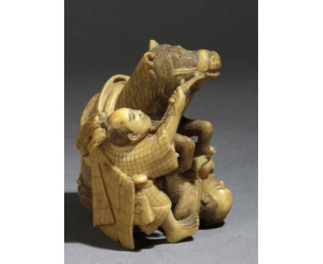 A late 19th century Japanese netsuke from Meiji period. Signed Onoryo. In carved elephant ivory portraying a horse kicking a 
