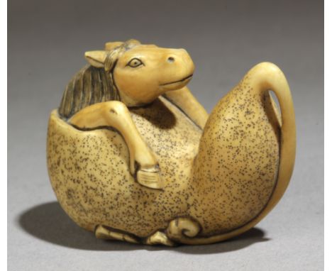 A 19th century Japanese netsuke from Meiji period. Signed. In carved elephant ivory portraying a horse trying to get out from