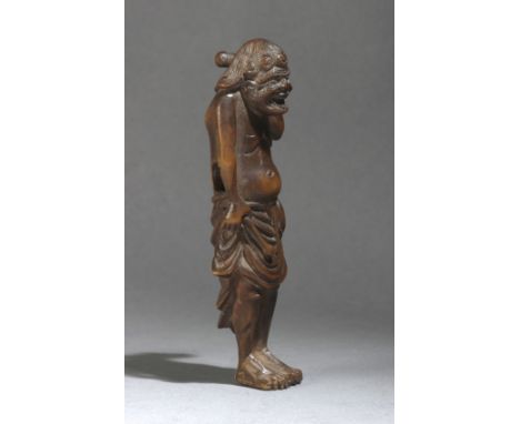 A 19th century Japanese netsuke from Meiji period. Not signed. In carved wood portraying a drummer carrying the sticks on his