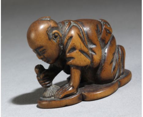  A 19th century Japanese netsuke from Meiji period portraying a keeling man sorryregreting and simbolically cleaning his hear