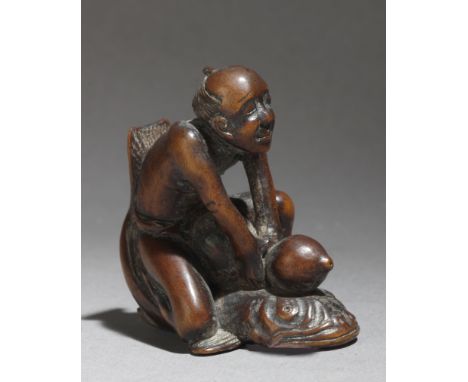 A mid 19th century Japanese netsuke from Edo period. Not signed. In carved wood portraying a "Kadori Miojin" sat on Namazu an