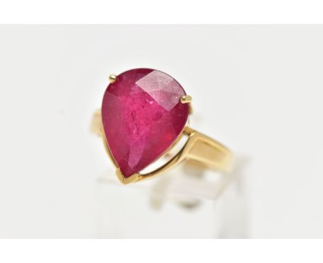 A 18CT GOLD GEM SET RING, a large pear cut glass filled ruby, approximate stone dimensions length 16mm x width 12mm, three pr