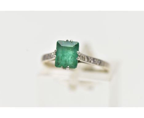 A EMERALD RING, single emerald cut stones, split prong set in white metal flanked with six single cut diamonds, milgrain deta