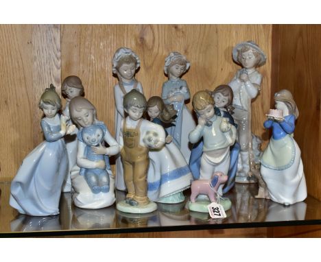 A GROUP OF ELEVEN NAO FIGURINES OF CHILDREN, to include a girl with puppy, a boy holding a telephone, a boy with a football, 