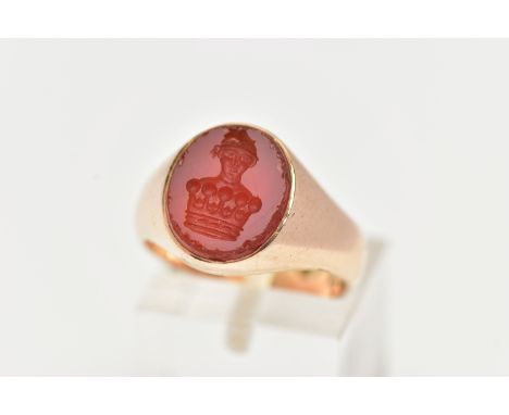 A YELLOW METAL SIGNET RING, an oval carnelian intaglio set within a heavy yellow metal ring, unmarked, ring size N 1/2 leadin
