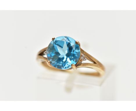 A 9CT GOLD DRESS RING, a circular cut topaz, four prong set in yellow gold, flanked with two colourless topaz stones, leading