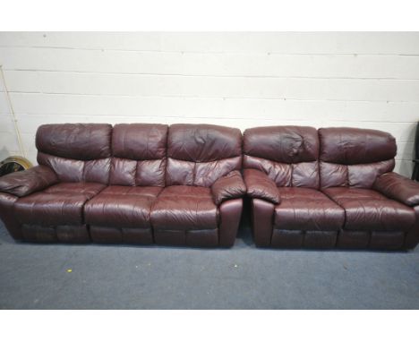 A RED LEATHER RECLINING SOFA SUITE, comprising an electric three seater sofa, and a manual reclining two seater sofa (conditi