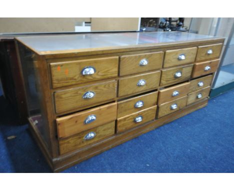 AN EARLY 20TH OAK HABERDASHERY SHOP DISPLAY COUNTER, with 16 drawers which graduated internally, width 178cm x depth 59cm x h
