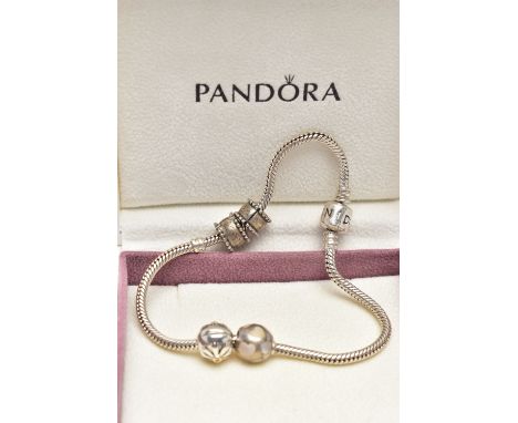 A PANDORA CHARM BRACELET, suspending four charms including a spherical charm inlaid with mother of pearl hearts, stamped 925 