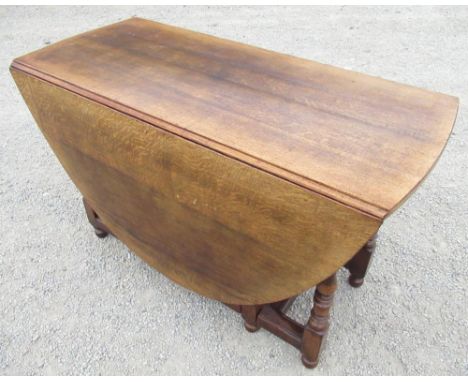 Titchmarsh &amp; Goodwin oak gate leg dining table with two D shaped leaves and end drawer on baluster turned and block suppo
