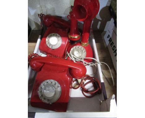 Red candlestick type telephone and two other red dial telephones (3) 