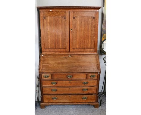 A George III oak bureau bookcase, the upper section with painted shelved interior over a lower section with fall front and fu