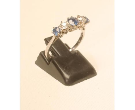 A SAPPHIRE AND DIAMOND FIVE STONE RING, the three graduated sapphires claw set with two small diamonds between, to a plain wh