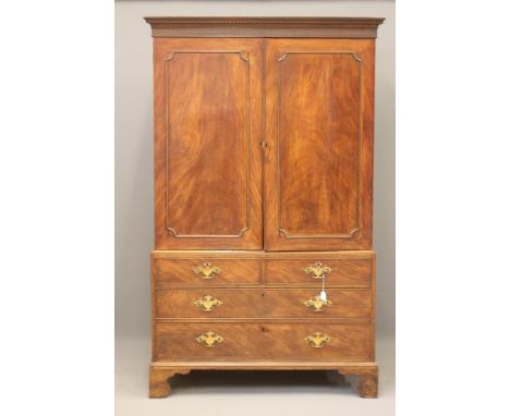 A GEORGIAN MAHOGANY LINEN PRESS, late 18th century, the dentil moulded cornice and fluted frieze over two doors applied with 