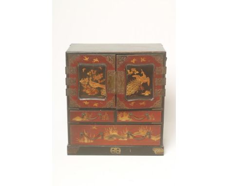 A JAPANESE LACQUER TABLE CABINET, c.1900, the two fielded panel doors decorated with peacocks in landscape, hinged and openin