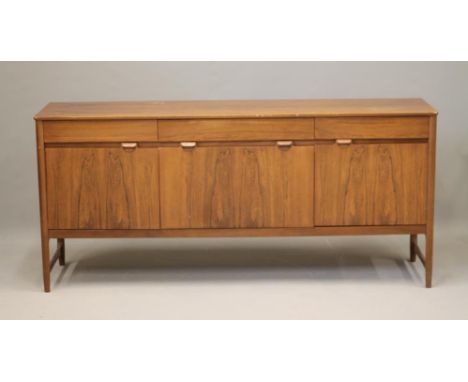 A ROSEWOOD SIDEBOARD, 1960/70's, of rounded oblong form, the moulded edged top over three plain frieze drawers, drop down cen