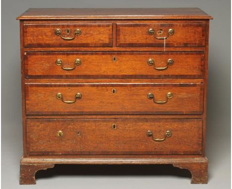 A GEORGIAN OAK AND MAHOGANY BANDED CHEST, the moulded edged top over two short and three long drawers with brass drop handles