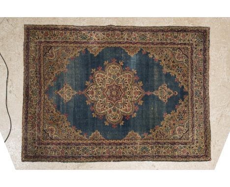 AN ANTIQUE KERMAN CARPET, the azure blue field with central lobed floral gul in puce, ivory, navy and pale blue, floral spran