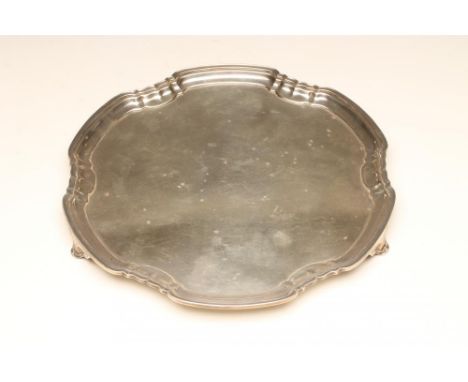 A SILVER SALVER, maker's mark FC, Sheffield 1942, of rounded hexagonal form with pie crust rim, raised upon three outcurved s