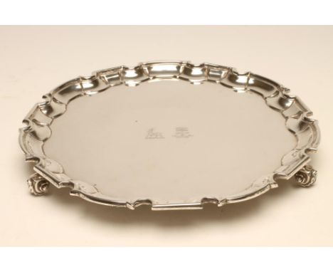 A SILVER SALVER, maker Huttons, Sheffield 1964, of shaped circular form with pie-crust rim and raised upon three knurl feet, 