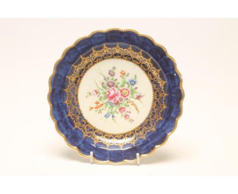 A FIRST PERIOD WORCESTER PORCELAIN PLATE, c.1770, of fluted circular form, centrally painted in polychrome enamels with a loo